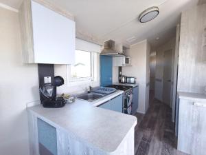 a small kitchen with a sink and a stove at Golden Sands sea holiday beach activities and relax in Mablethorpe
