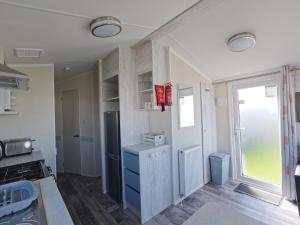 a kitchen with a refrigerator and a window at Golden Sands sea holiday beach activities and relax in Mablethorpe