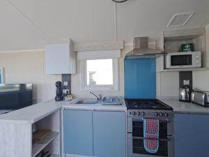 a kitchen with a stove and a sink at Golden Sands sea holiday beach activities and relax in Mablethorpe +29 photos