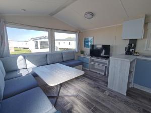 a living room with a couch and a kitchen at Golden Sands sea holiday beach activities and relax in Mablethorpe
