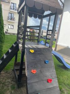 a wooden play structure with three toys in the grass at Royal Boutique in Râşnov