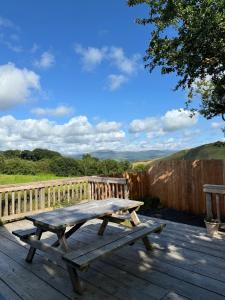 a picnic table sitting on a wooden deck at Glyndwr Way Cabin in Machynlleth +10 photos