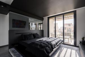 a bedroom with a large bed and a large window at The Ape House in Madīnat aţ Ţalāʼi‘