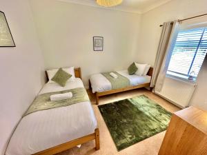 a small room with two beds and a window at Family Three Bedroom Home - Outbuilding Games Room - Walk to Town and Beach - Free Parking in Bournemouth