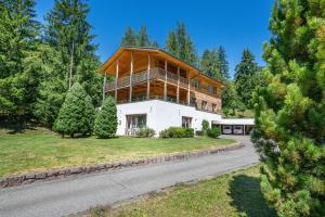 une maison avec une façade en bois sur une route dans l'établissement Apartments Villa Jim, à Ortisei