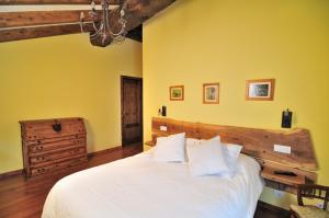 a bedroom with a white bed and yellow walls at Casa Corral - Casas de Aldea in Monón
