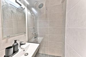ein weißes Badezimmer mit Waschbecken und Dusche in der Unterkunft Studio agréable et tout équipé - Montreuil in Montreuil
