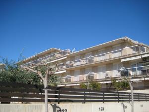 een appartementencomplex met een boom ervoor bij Apartamento Illa Mar in Sant Carles de la Ràpita