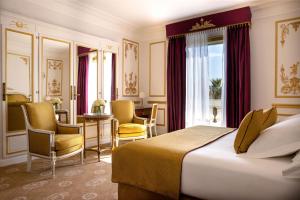 a hotel room with a bed and a table and chairs at Hotel Le Negresco in Nice