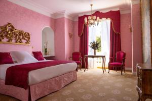 a bedroom with a large bed and pink walls at Hotel Le Negresco in Nice