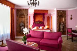 a living room with a purple couch and a bed at Hotel Le Negresco in Nice