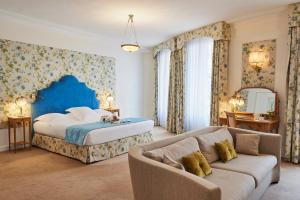 a bedroom with a bed and a couch at Hotel Le Negresco in Nice