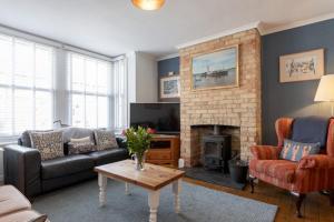 a living room with a couch and a fireplace at St Elmo in Southwold