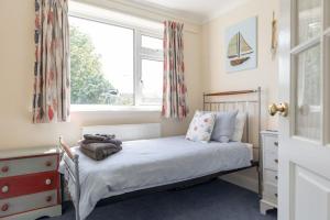 a small bedroom with a bed and a window at St Elmo in Southwold