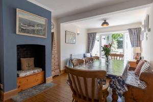 a dining room with a table and a fireplace at St Elmo in Southwold