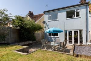 a table with an umbrella in the backyard of a house at St Elmo in Southwold