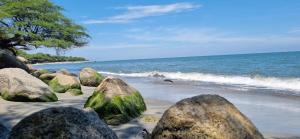 a group of rocks on a beach with the ocean at Apartamento Dorado Sunset in Santa Marta