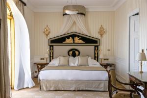 a bedroom with a king sized bed with a canopy at Hotel Le Negresco in Nice