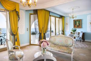 a living room with yellow curtains and a couch at Hotel Le Negresco in Nice