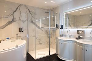 a bathroom with a shower and a sink and a tub at Hotel Le Negresco in Nice