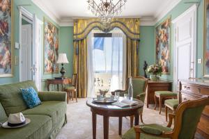 a living room with a couch and a table at Hotel Le Negresco in Nice