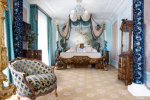 a bedroom with a bed and a chair at Hotel Le Negresco in Nice