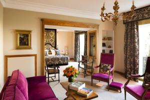 a living room with purple furniture and a bed at Hotel Le Negresco in Nice