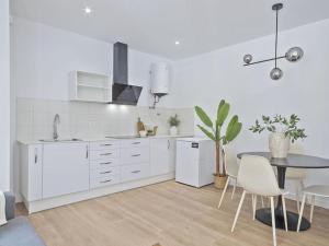 a white kitchen with a table and a dining room at Refugio Costero a 2 minutos de Playa Sagunto A4 in Puerto de Sagunto +5 photos