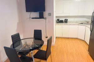 Un comedor con una mesa de cristal y sillas negras. en Miami Beach Apartments by MiaRentals, en Miami Beach