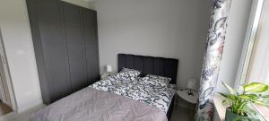 Dormitorio pequeño con cama con cabecero negro en Apartament Od Nowa Zdrój, en Busko-Zdrój