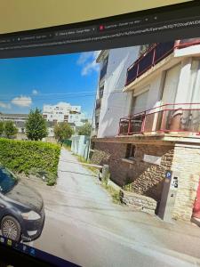 a television screen with a picture of a building at La Déferlante - hyper centre - parking privé - 300 m plage in Saint-Nazaire