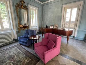 a living room with two chairs and a piano at Beach Villa Fiorina in Ghiffa