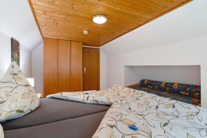 une chambre avec un lit et un plafond en bois dans l'établissement Schwarzwald Buchenhof, à Zell am Harmersbach