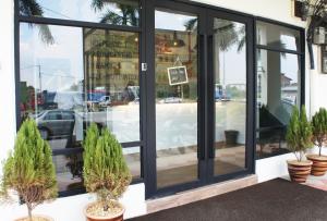 a store front with large windows and potted plants at No.31 Maple Inn in Simpang Ampat