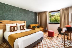 シャモニー・モンブランにあるBig Sky Hotel & Spaの大きなベッドと椅子のあるホテルの部屋