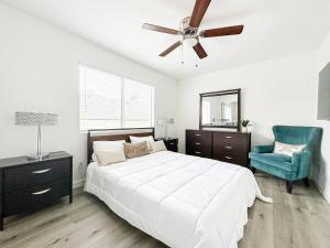 a bedroom with a bed with a ceiling fan and a blue chair at Charming 2-BR, 2-Story Home in Heart of LA - BR4 in Los Angeles