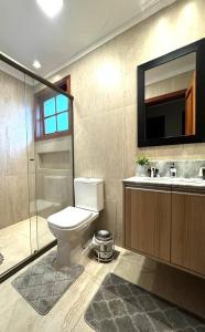 a bathroom with a toilet and a sink and a shower at 3 dormitórios ao lado da Rua Coberta in Gramado