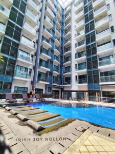 a swimming pool in front of a tall building at Condotel Near Naia Terminal 3 in Manila