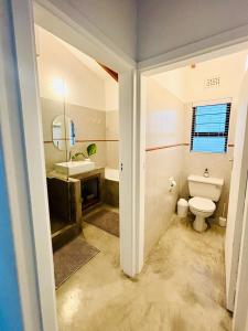 a bathroom with a toilet and a sink at UMDLOTI House - Upper private level- Beach Road - LOCATION in Umdloti