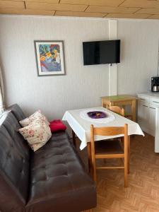 ein Wohnzimmer mit Sofa und Tisch in der Unterkunft Ferien-Bungalow -2- im Seebad UeckermündeOT Bellin in Ueckermünde