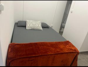 a bed with a blanket on top of it at Casa da alegria in Vieira de Leiria