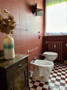 baño con aseo y jarrón de flores en LR Deluxe Apartments - Maison Zeno, en Milán 23 fotos más