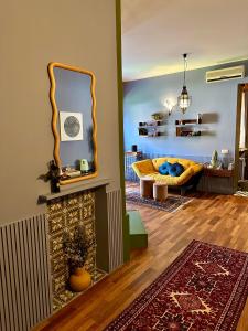 sala de estar con sofá amarillo y espejo en LR Deluxe Apartments - Maison Zeno, en Milán