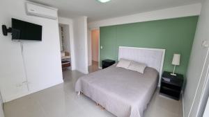 a bedroom with a bed and a tv on a wall at Nancy Forest 888 in Punta del Este +66 photos