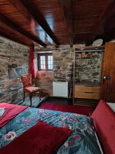 a bedroom with a bed and a chair in a room at Azoka by the River- Proença-a-Nova in Maljoga de Proença