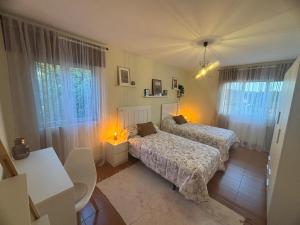 a bedroom with two beds and two windows at Casa de Mucha in Camariñas