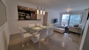 a dining room and living room with a glass table and chairs at Nancy Forest 888 in Punta del Este