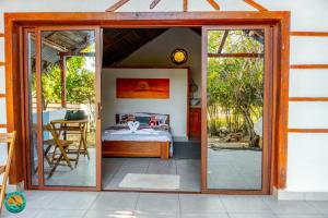 a bedroom with a bed and a sliding glass door at Ny Fano Kite Lodge in Ivovona
