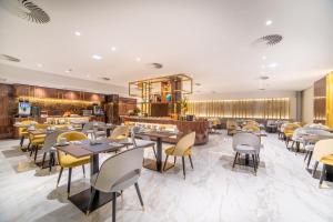 里斯本VIP Executive Suites do Marquês Hotel的有桌椅和酒吧的餐厅