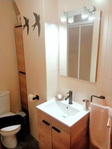 a bathroom with a sink and a toilet and a mirror at PAUTANA, céntrico y a pocos minutos de Vigo in Cangas de Morrazo